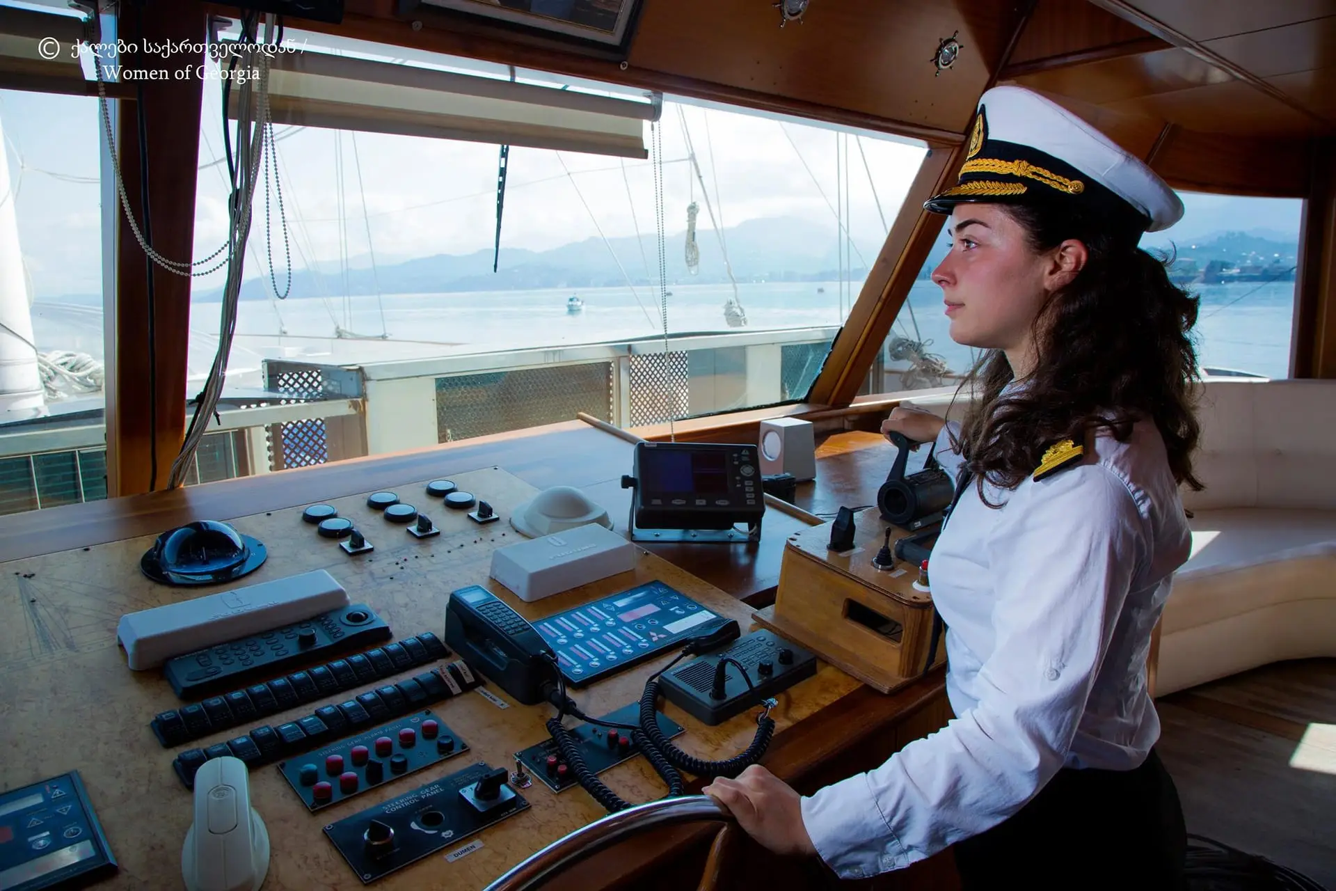 A woman officer on a ship's bridge looking out to sea